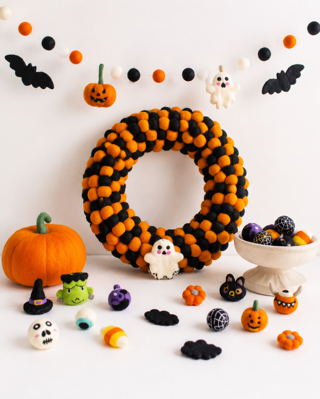 Wholesale Halloween decorations featuring handmade felt pumpkins, ghosts, bats and garlands for boutique retailers.
